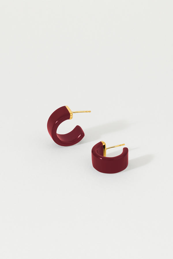 A pair of plum huggie earrings with 18K gold plated sterling silver studs on a white background.